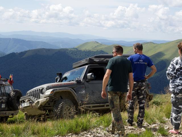 Ekipažas prie Wrangler žiūri į kalnų panoramą