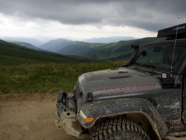 Wrangler su TOKA FOOD užrašu ant kapoto, kalnai fone