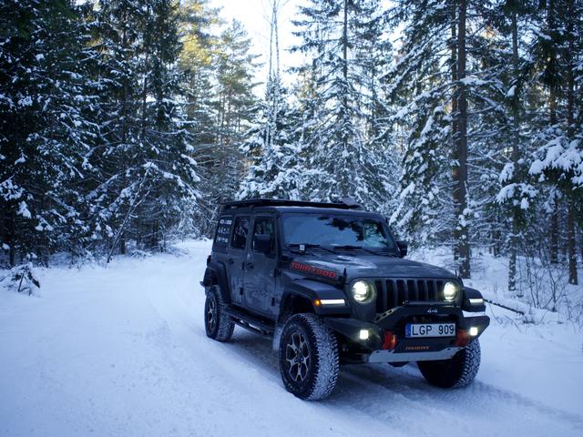 Wrangler priekis žiemos miške su įjungtais žibintais